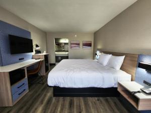 a hotel room with a bed and a desk and a television at Smart Stay Lafayette in Lafayette