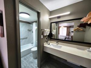 a bathroom with a sink and a toilet and a mirror at Smart Stay Lafayette in Lafayette