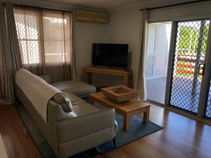 sala de estar con sofá y TV en Endeavour Reach, en Cooktown