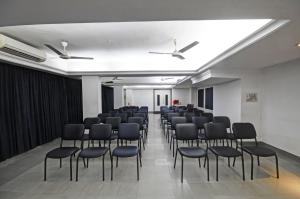 Una habitación con un montón de sillas. en Hotel Roopa, en Mysore