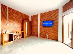 a bedroom with a brick wall and a tv on a wall at Puu Pau Hotel & Coffee Shop in Labuan Bajo +20 photos