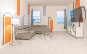 un soggiorno con divano e tavolo di Waterfront Brand New Modern Luxury 8 BR pool house! Sleeps 16 a Kissimmee
