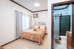 a small bedroom with a bed and a bathroom at Siesta Siargao in General Luna