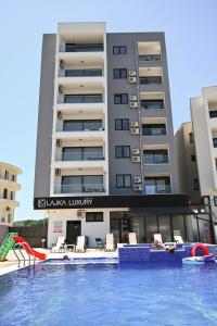 a hotel with a swimming pool in front of a building at Hotel Lajka Luxury in Ulcinj