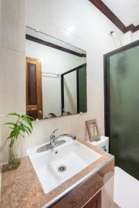 La salle de bains est pourvue d'un lavabo, d'un miroir et de toilettes. dans l'établissement Siesta Siargao, à General Luna