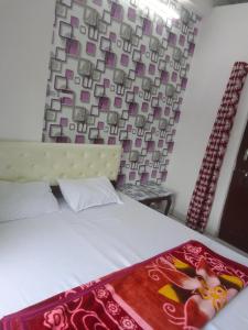 a bedroom with a bed with a red blanket on it at Shree Krishna Hotel in Udaipur