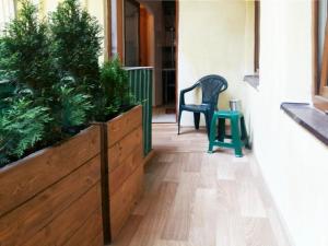 una maceta de madera con una silla y un taburete verde en Austrian Lviv Apartments, en Leópolis