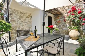 un patio con una mesa con copas de vino y flores en B&B La Villetta, en Dolceacqua