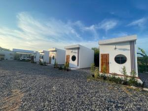 una fila de casas blancas en un camino de grava en Muji House & Cafe', en Non Sang