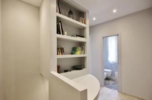 uma escada branca num quarto com uma estante de livros em B&B La Villetta em Dolceacqua