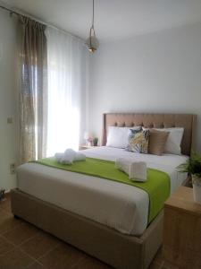 a bedroom with a large bed with a green blanket at Anna's Cozy Flat in Lefkada