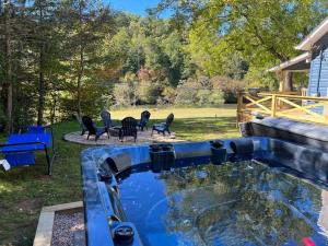 una piscina en un patio trasero con sillas y mesa en Riverside Relaxer w/Hot Tub+Fire Pit +Wifi & view, en Franklin