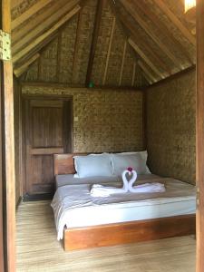 a bed with two swans on it in a room at Vanilla Garden in Tetebatu