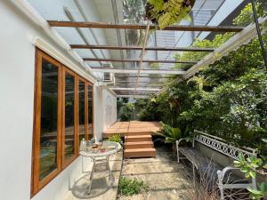 a conservatory with a table and chairs and plants at home near MRT Tha Phra Villa sookkasem in Bangkok Yai