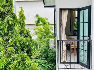home near MRT Tha Phra Villa sookkasem في Bangkok Yai: باب مفتوح على حديقة مع طاولة