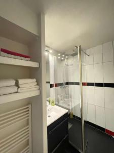 uma casa de banho com um chuveiro, um lavatório e uma banheira em Appartement La Baule - Plage Benoît em La Baule
