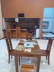 una mesa de madera y sillas en la cocina en Ijen Transito 2 homestay, en Ketapang