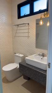 baño con aseo y lavabo y ventana en Look at Home Lamphun en Lamphun