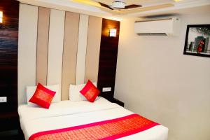 a bedroom with a bed with red and white pillows at Hotel Magic Tree Karol Bagh Metro Station New Delhi in New Delhi