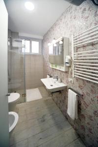 een badkamer met een wastafel, een toilet en een spiegel bij konak rooms l Skanderbeg Square in Tirana