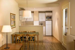 a kitchen and dining room with a table and chairs at Apartaments Shusski in Encamp