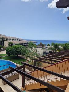 balcone con vista su un resort con piscina di Ocean Sunset Villa a San Miguel de Abona