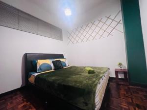 ein Schlafzimmer mit einem Bett mit einer grünen Decke darauf in der Unterkunft The Heritage@Selesa Hillhomes Bukit Tinggi Berjaya Hills Bentong in Bentong + 19 Fotos