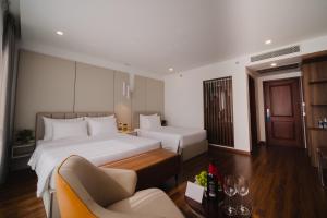 um quarto de hotel com duas camas e um sofá em Danitel Halong em Ha Long