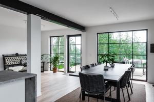 Villa Röd في Habo: غرفة طعام مع طاولة وكراسي ونوافذ