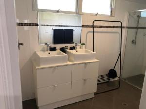 a bathroom with two white sinks and a mirror at Endeavour Reach in Cooktown +19 photos