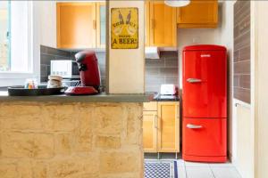 een rode koelkast in een keuken met een aanrecht bij Le petit Marc in Kingersheim