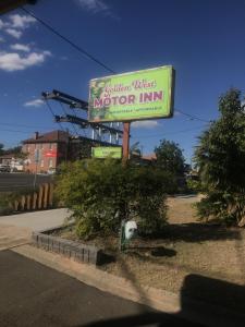 a sign for a motor inn on a street at Golden West Motor Inn in Miles