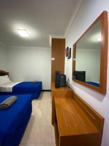 Cette petite chambre comprend 2 lits et un miroir. dans l'établissement Karsa Utama Hotel, à Jakarta