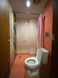 y baño con aseo y ducha. en Karsa Utama Hotel, en Yakarta