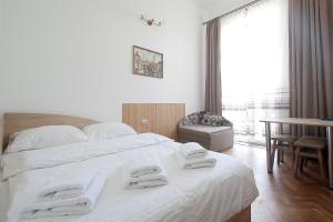 a bedroom with a large white bed with towels on it at Deluxe Apartments on Doroshenka 29 in Lviv