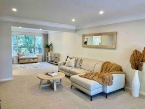 uma sala de estar com um sofá e uma mesa em Kookaburra House - Terrigal Beach em Terrigal