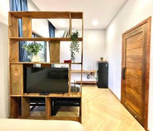 a living room with a tv and a book shelf at MIDMOST CASA in Can Tho