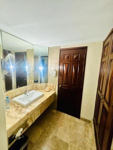 een badkamer met een wastafel en een grote spiegel bij Hotel Real de Don Juan in Tepic