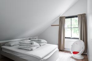 sypialnia z łóżkiem z białą pościelą i oknem w obiekcie Villa Röd w mieście Habo
