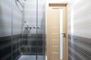a shower with a glass door in a bathroom at Deluxe Apartments on Doroshenka 29 in Lviv