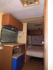 an interior view of an rv with a desk and a bed at Campeggio Ricortola Mare in Marina di Massa