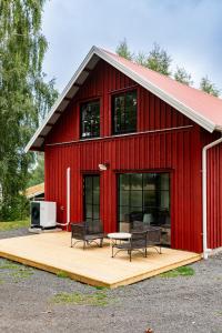 une grange rouge avec deux chaises et une table sur une terrasse dans l'établissement Villa Röd, à Habo