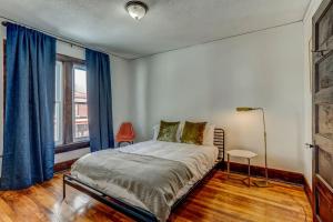 une chambre avec un grand lit avec des rideaux bleus dans l'établissement Luxe Mid-Century Styled Historic Townhouse #1, à Detroit