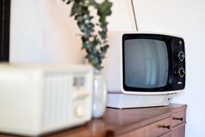 a tv sitting on top of a wooden table at Luxe Mid-Century Styled Historic Townhouse #2 in Detroit