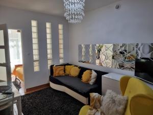 a living room with a couch and a chandelier at Apartamenty Tomaszów Lubelski - Żółty in Tomaszów Lubelski