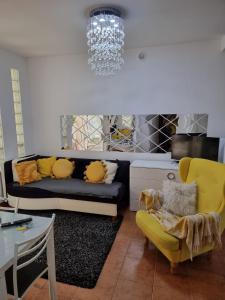 een woonkamer met een bank en een gele stoel bij Apartamenty Tomaszów Lubelski - Żółty in Tomaszów Lubelski
