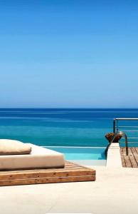 una piscina con una cama junto al océano en Tsamis Zante Suites, en Kypseli