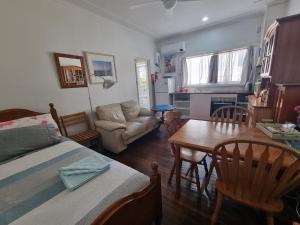 a living room with a bed and a table and chairs at Kurranulla Sapphire - Unit 1 in Cronulla
