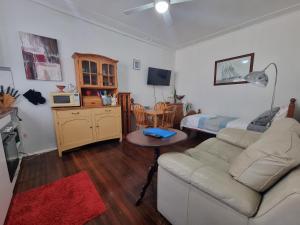 a living room with a couch and a bed at Kurranulla Sapphire - Unit 1 in Cronulla