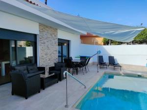 un patio con piscina, mesa y sillas en Villamolinos, villa con piscina privada. en San Pedro del Pinatar